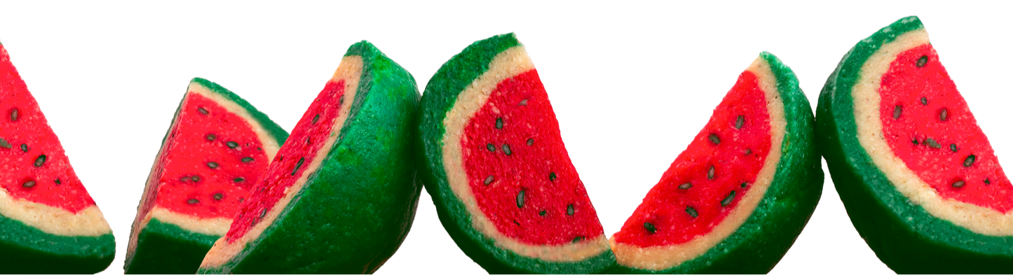 Five slices of watermelon mithai arranged in a row on a white background